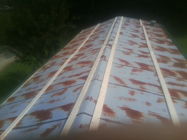 Rusted metal roof panels with new wood purlins before replacement — Storm Damage Roof Repair in Feeding Hills by Roofing Brothers