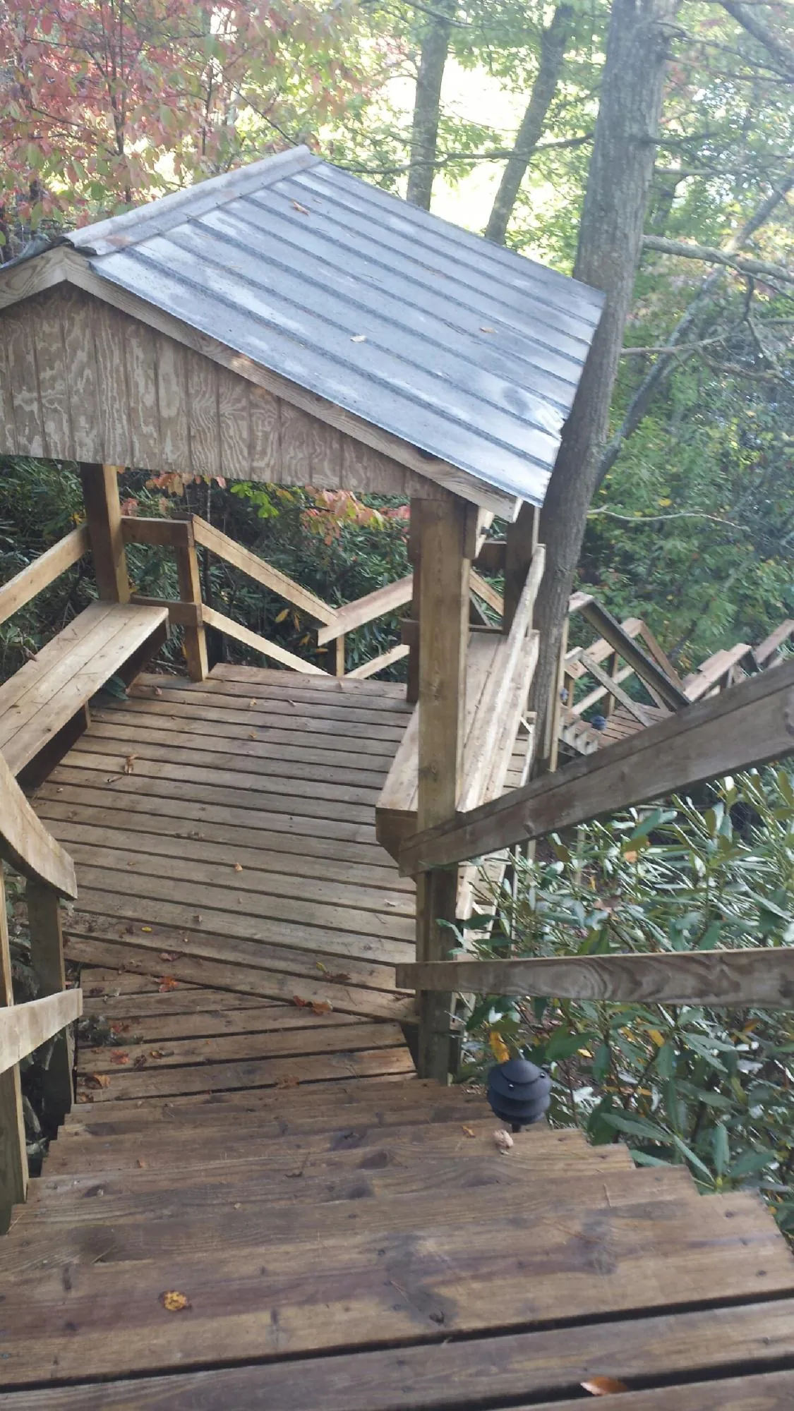 Metal roofed shelter over wooden steps on a wooded walkway — Skylight Repair & Installation work by our crew in Feeding Hills