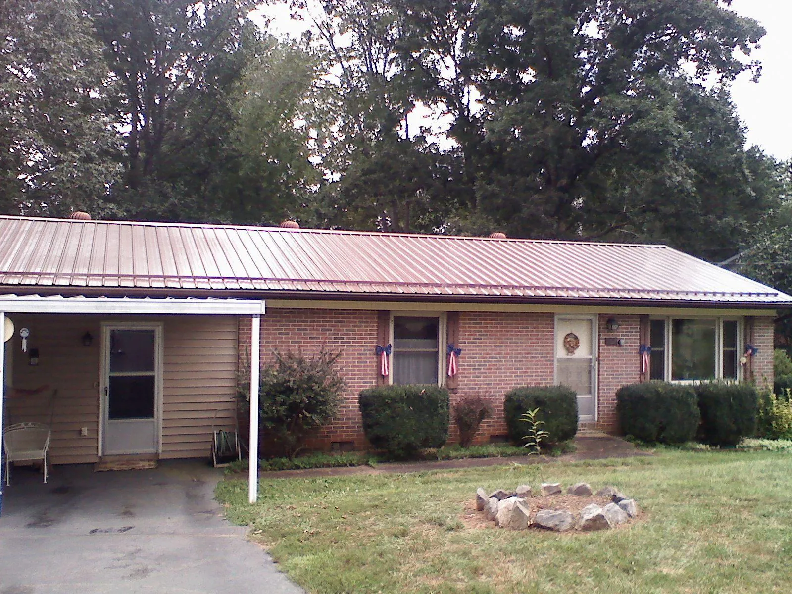 Bronze metal roof and carport on a brick ranch home — Roof Repair work by our crew in Feeding Hills